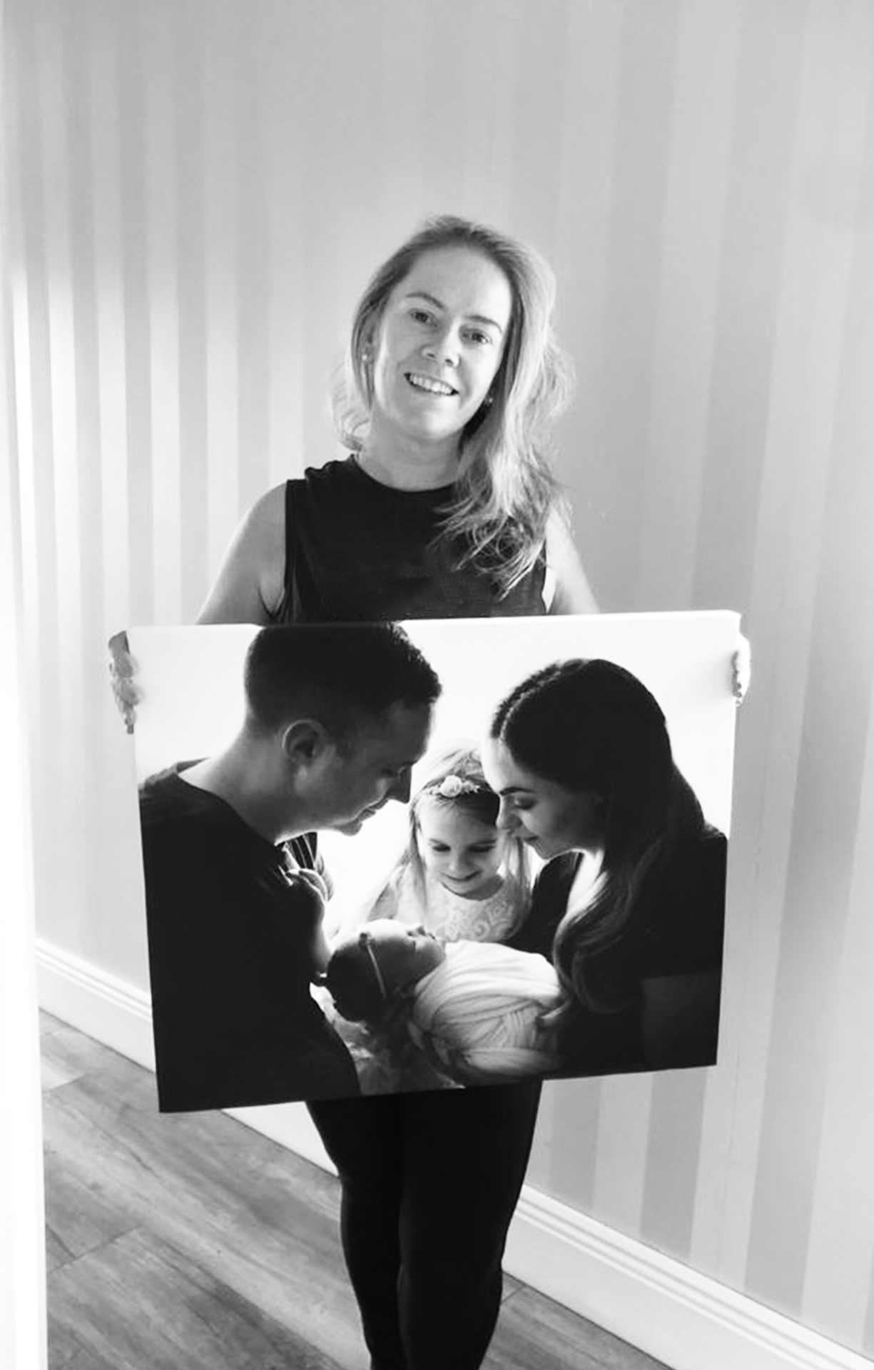 Wallart Dublin Photo of a Newborn Photographer holding a piece of wall art of a newborn baby photo session Dublin
